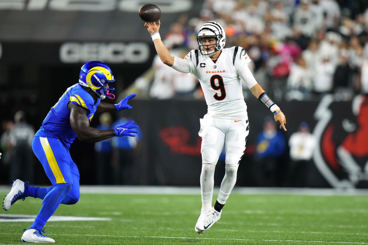 Joe Burrow throws as a Rams player runs toward him